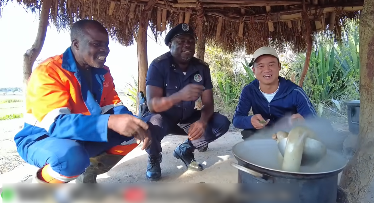 Công Giáp (trái) và Sơn Thạch (phải) giới thiệu với người dân châu Phi về món cháo lòng của Việt Nam