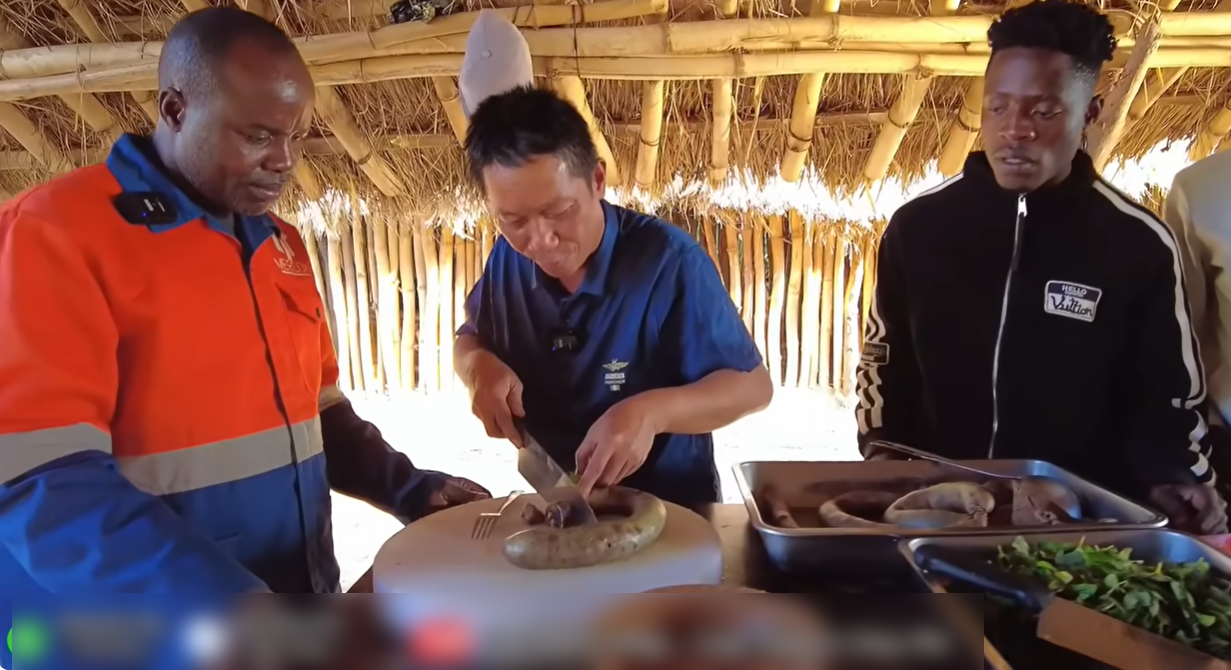 Công Giáp (trái) và Sơn Thạch (phải) giới thiệu với người dân châu Phi về món cháo lòng của Việt Nam