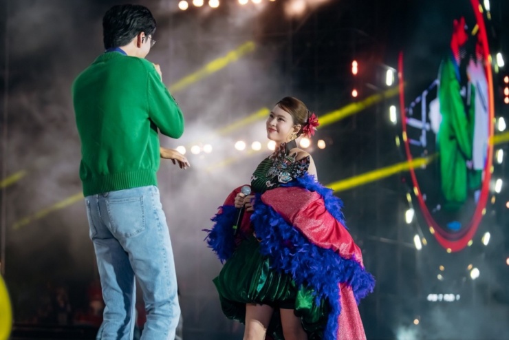 Hoàng Thùy Linh chọn bộ váy thân bồng của nhà thiết kế Linh San, tạo điểm nhấn với áo choàng lông vũ. Đôi nghệ sĩ khiến fan reo hò khi nắm tay nhau biểu diễn, bắt nhịp cho khán giả hát.