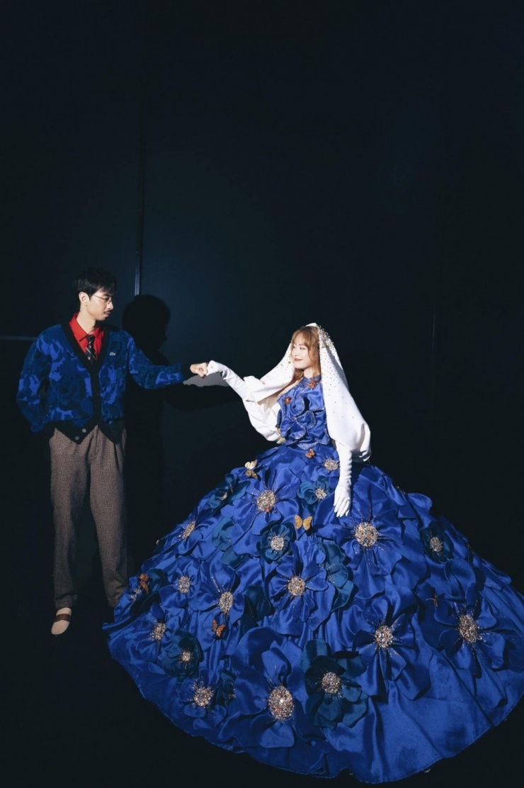 Ở hậu trường một sự kiện mừng năm mới, cô diện bộ đầm đính kết cầu kỳ, mix đồng điệu cùng Đen Vâu với màu xanh coban.