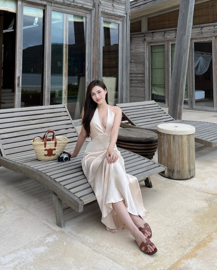 Trong một lần đi nghỉ dưỡng, người đẹp kết hợp maxi lụa xẻ ngực với dép Hermes và túi Celine.