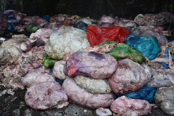 Các túi nilon chứa mỡ động vật nằm la liệt trên nền xi măng bẩn. Ảnh: Công an Đà Nẵng