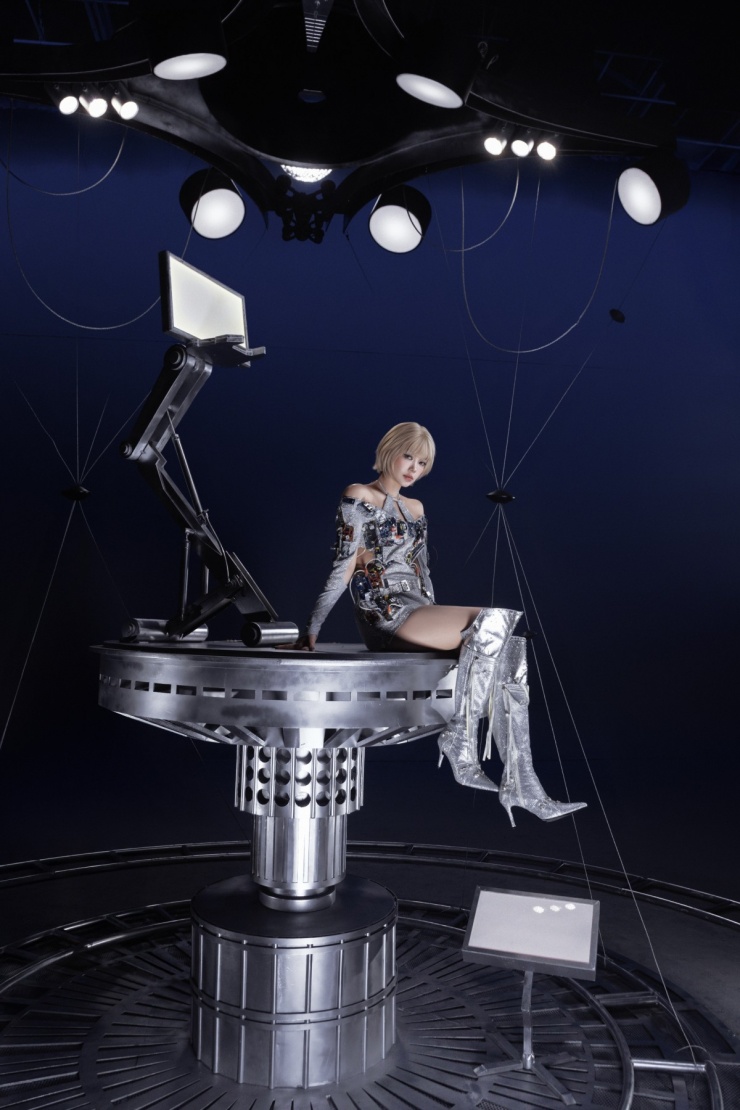 Cô diện váy ngắn sequin ánh bạc đính phụ kiện điện tử, thể hiện hình ảnh giải phóng, vượt qua giới hạn.