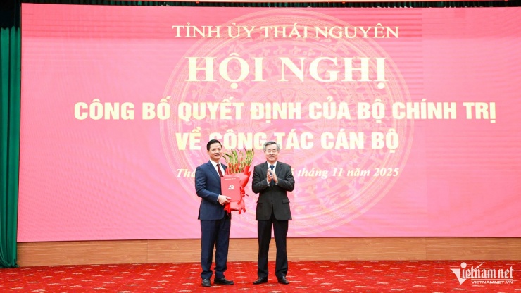 Ông Nguyễn Quang Dương, Phó trưởng Ban Tổ chức Trung ương trao quyết định và tặng hoa chúc mừng ông Vương Quốc Tuấn