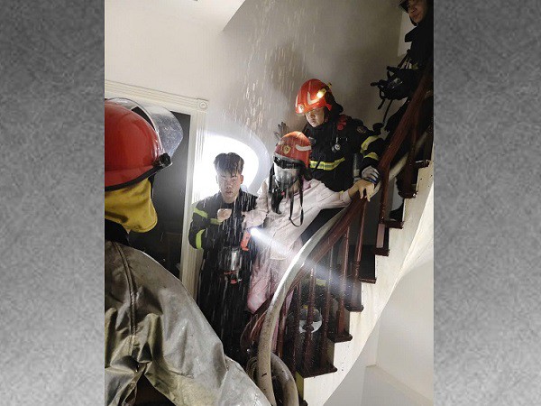 Cảnh sát đưa nạn nhân nữ xuống vị trí an toàn bằng cầu thang bộ. Ảnh: Công an TP Hà Nội.