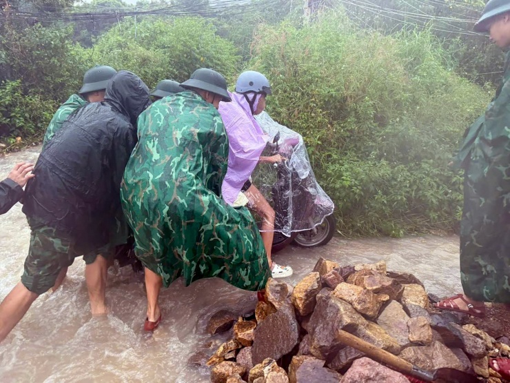 Lực lượng chức năng hỗ trợ, đưa người dân ở thôn Thành Phát (phường Nam Nha Trang) sơ tán đến nơi an toàn. Ảnh: Văn Tân