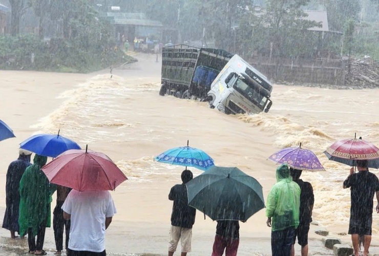 Chiếc xe tải bị cuốn trôi khi đi qua Quốc lộ 15D. Ảnh: M.T