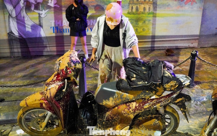Hiện trường nhiều xe máy bị đổ, ngã khi đi qua đoạn phố Tôn Đức Thắng bị tràn bùn lỏng.