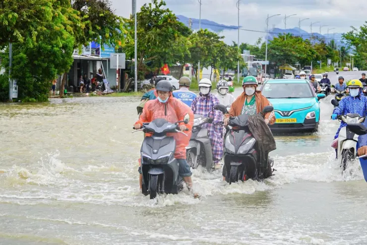 Nhiều người vất vả di chuyển qua chỗ ngập để về nhà.