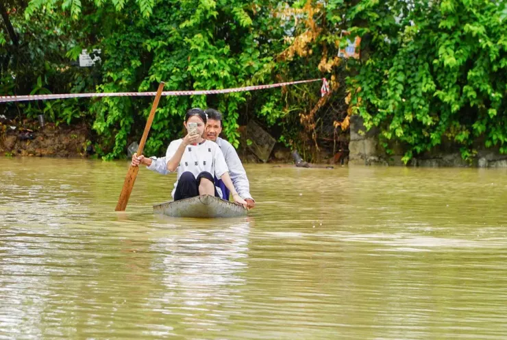 Người dân dùng thuyền ra khỏi khu vực ngập lụt ở phường Tây Nha Trang.