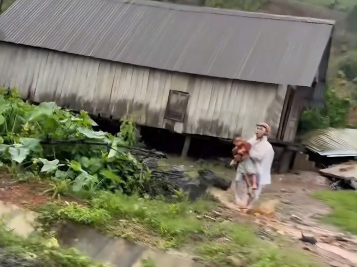 Người đàn ông ôm cháu nhỏ tháo chạy khỏi khu vực sạt lở đất