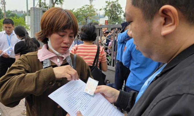 Đại diện chủ đầu tư kiểm tra CCCD và hồ sơ đăng ký mua nhà của khách hàng trước khi vào lấy số thứ tự. Ảnh: Viglacera