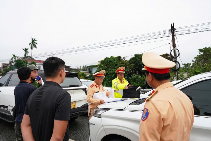 Lực lượng CSGT lập biên bản xử phạt các trường hợp đậu đỗ ô tô trên cầu để tránh lũ vào sáng 17-11.