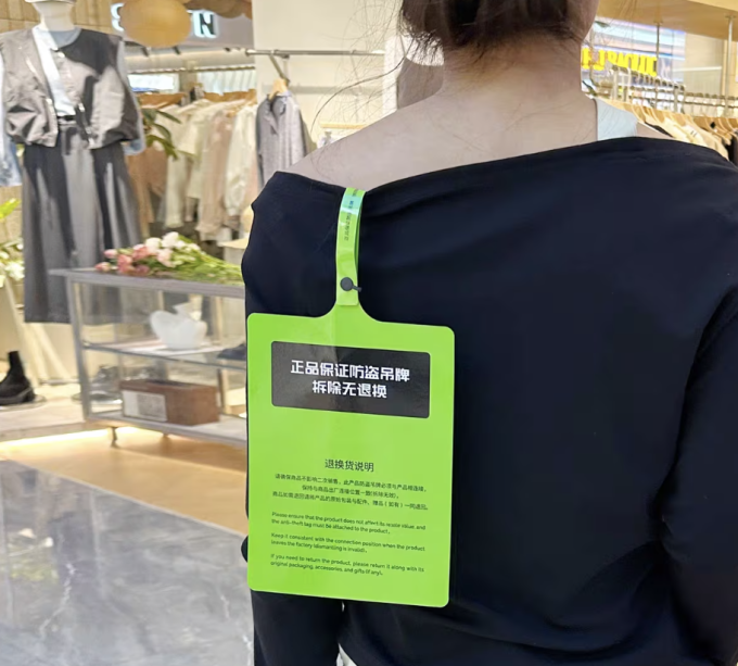 Một chiếc mác áo cỡ A4, làm từ chất liệu cứng, màu sắc nổi bật, gây khó chịu khi mặc. Ảnh: CNA