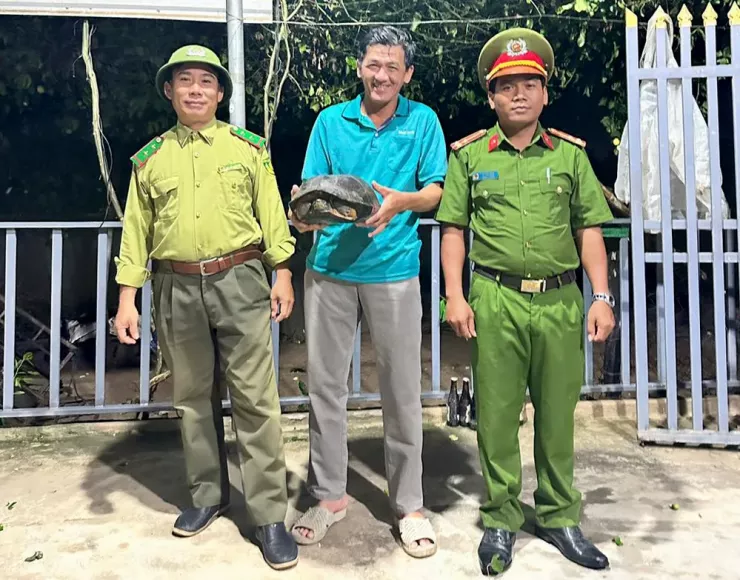 Ông Nguyễn Thanh Hùng giao nộp con rùa đầu đen quý hiếm. Ảnh: CÔNG AN XÃ PHƯỚC HẬU