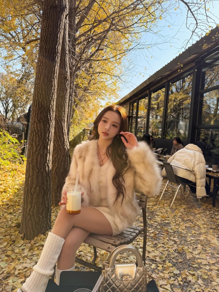 Huyền Baby lên đồ phong cách tiểu thư với áo khoác lông, tất len cao đến bắp chân khi ngắm lá vàng Hàn Quốc. Outfit tông trắng kem giúp cô được nhiều khán giả khen trông như 'tiểu thư tài phiệt'.