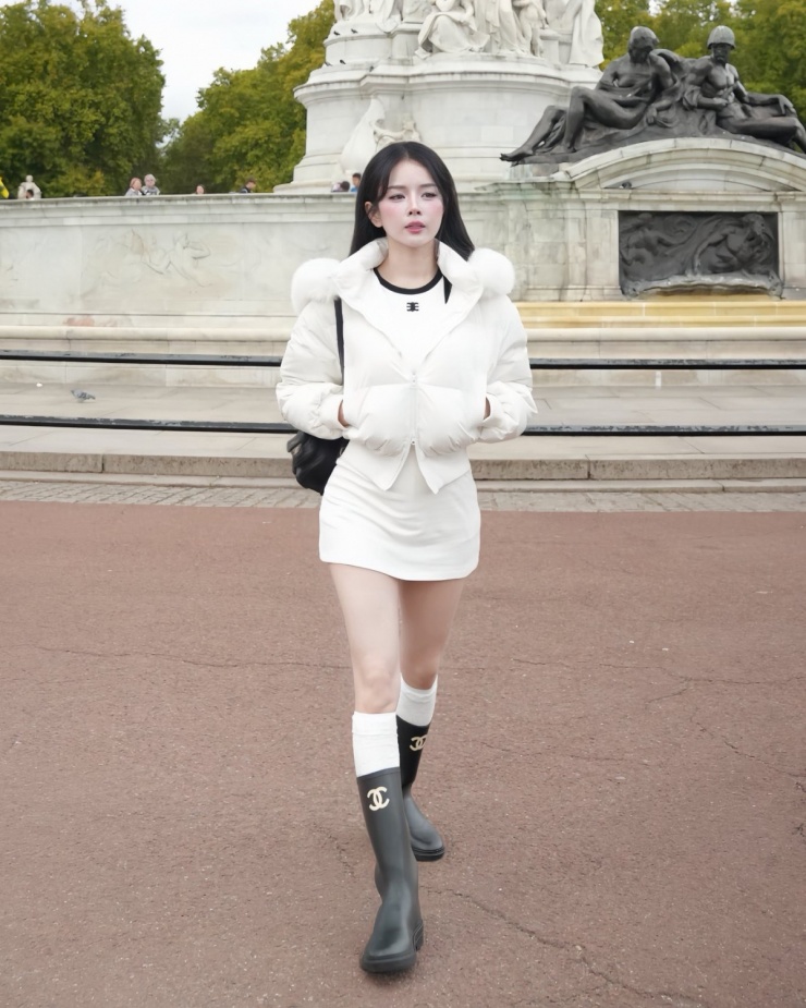 DJ Mie chống chọi với thời tiết lạnh giá ở Anh mùa đông với áo khoác phao phối cổ lông. Cô kết hợp chân váy ngắn và boots cao, tạo phong cách 'trên đông dưới hè' hợp mốt.