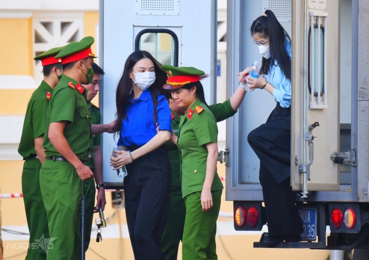 7h sáng, các bị cáo được dẫn giải đến TAND TP HCM. Hoa hậu Thùy Tiên mặc áo xanh thẫm, đeo khẩu trang, được dẫn xuống từ xe thùng. Theo sau cô là Hằng Du Mục. Họ tỏ ra bình tĩnh, quay ra phía cổng nhìn về đám đông đang dõi theo họ từ xa.