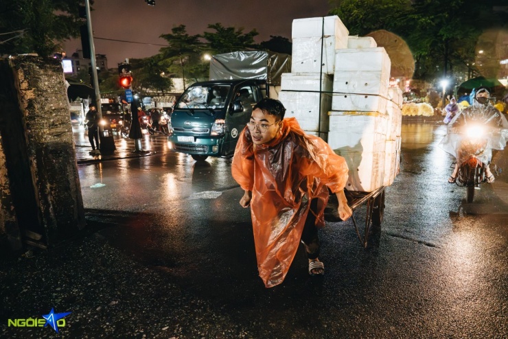 Người đàn ông làm cửu vạn oằn mình kéo hàng nặng vào chợ Long Biên.