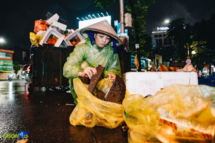 Chị Nguyễn Thị Mến (42 tuổi) công nhân vệ sinh phường Ba Đình, mỗi ngày bắt đầu ca làm từ 17h chiều hôm trước và kết thúc lúc 4h sáng hôm sau. Trời rét khiến công việc thu gom rác vất vả hơn, song chị đã quen với nhịp làm việc trong giá lạnh. 'Hôm nay lạnh hơn bình thường nhưng tôi chuẩn bị áo ấm, áo mưa. Làm mãi rồi nên cũng quen tay chân', chị cho biết.