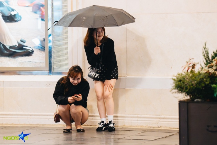 Gió thổi từng cơn khiến đôi bạn trẻ co người lại khi chờ bạn trên phố Tràng Tiền.