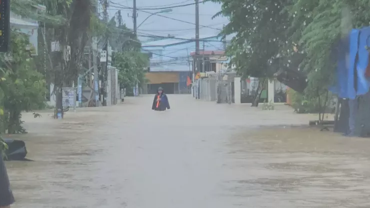 Một số người cố gắng vượt cơn lũ để đi mua thức ăn, nước uống.