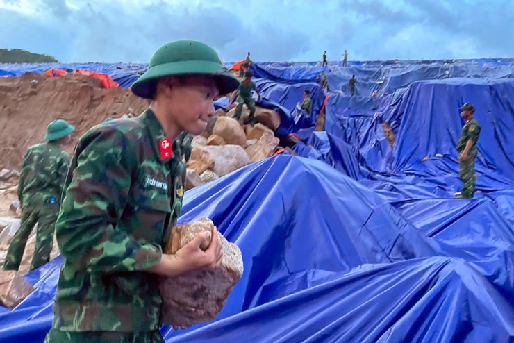 Lực lượng đặc công nước hỗ trợ khẩn cấp xử lý xói mòn, sạt lở tại hồ nước. Ảnh: N.X