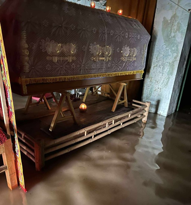 Một gia đình kê quan tài người thân lên cao tránh lũ