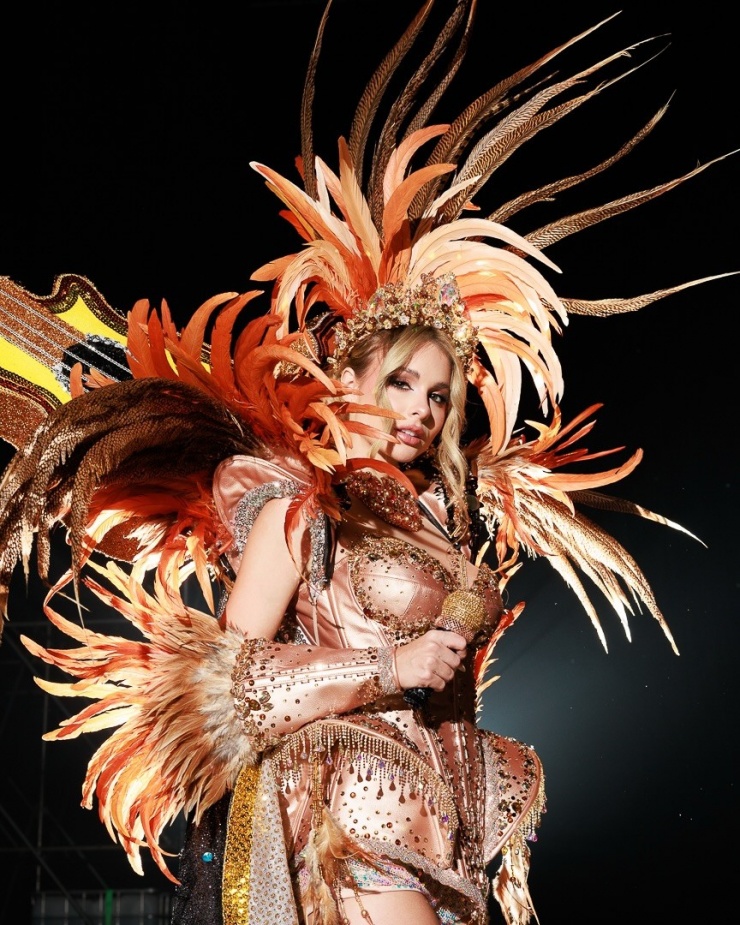 Miss Universe Argentina 2025 Aldana Masset xuất hiện trong bộ trang phục được thiết kế theo phong cách nghệ sĩ trình diễn lễ hội Carnival. Cô 25 tuổi, biết chơi ba loại nhạc cụ. Năm 2022, cô giữ vai trò giọng hát chính của ban nhạc Agapornis.