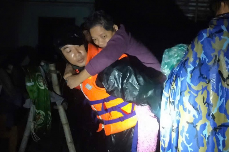 Chiến sĩ đặc công nước cõng người dân đến vị trí an toàn. Ảnh: NX