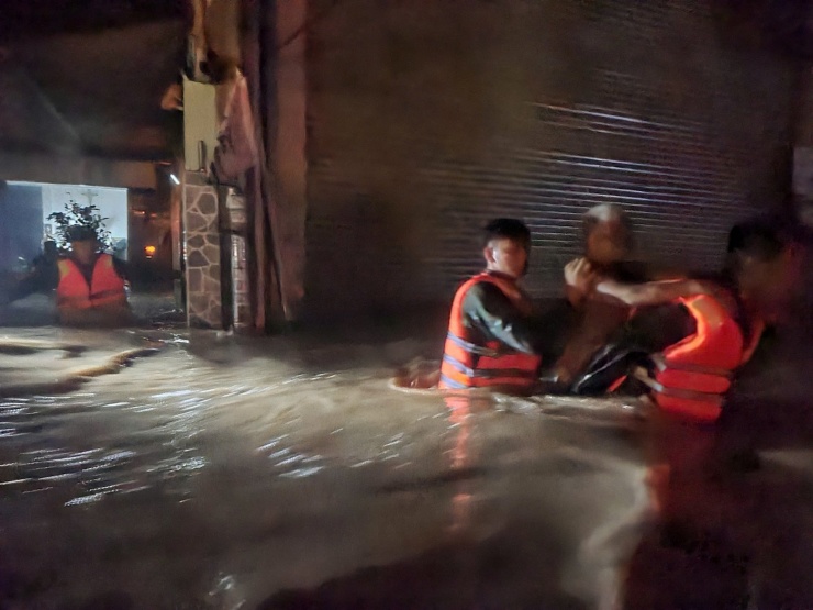 Đặc công nước giữa dòng lũ cứu người dân ra khỏi khu vực ngập lụt nguy hiểm. Ảnh: NX