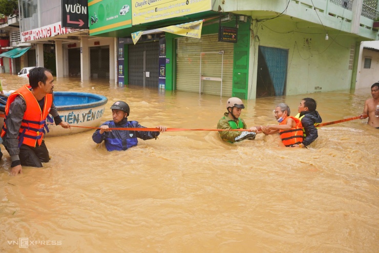 Ông Nguyễn Văn Báo sống trên đường 23 Tháng 10 được lực lượng chức năng cứu hộ qua dòng nước xiết.