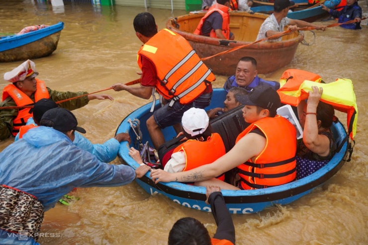 Các đội cứu hộ phường Tây Nha Trang dùng thuyền thúng chở người, tài sản đến nơi an toàn. Nước lũ chảy xiết trên đường khiến việc cứu hộ gặp khó khăn.