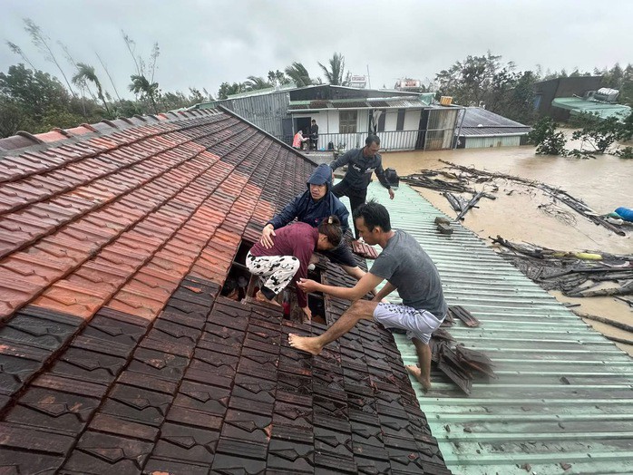 Nước lũ dâng cao, sắp tràn qua nóc nhà nên người dân Gia Lai phải tháo ngói để thoát ra bên ngoài