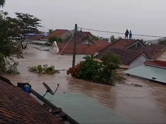 Nhà ngập tới nóc, nhiều người leo lên nóc chờ ứng cứu.