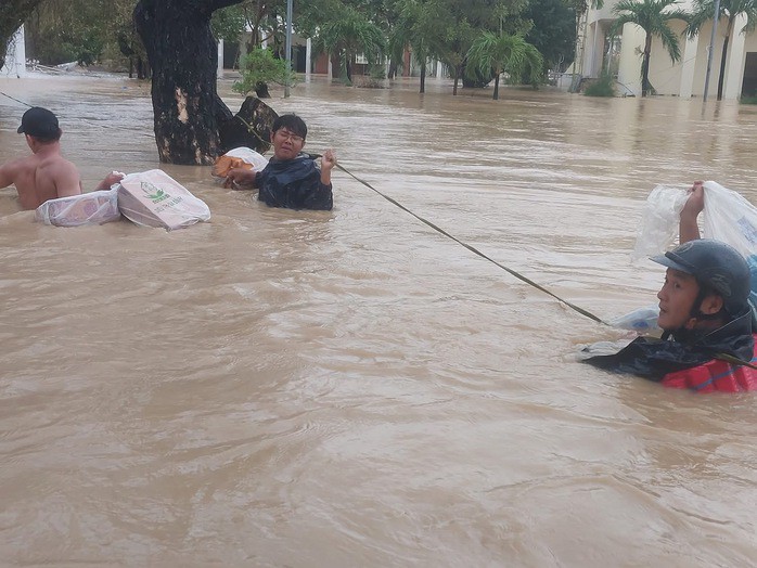 Giảng viên Trường Cao đẳng Kỹ thuật Công nghệ Quy Nhơn bơi giữa dòng nước lũ tiếp tế lương thực cho sinh viên trong ký túc xá.