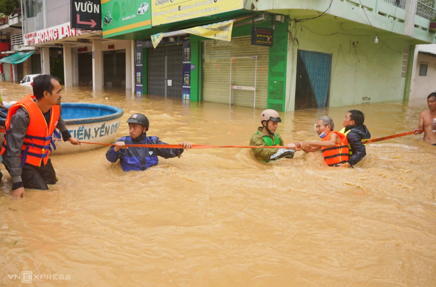 Lực lượng chức năng hỗ trợ người dân qua điểm ngập lụt ở phường Tây Nha Trang, ngày 20/11. Ảnh: Bùi Toàn