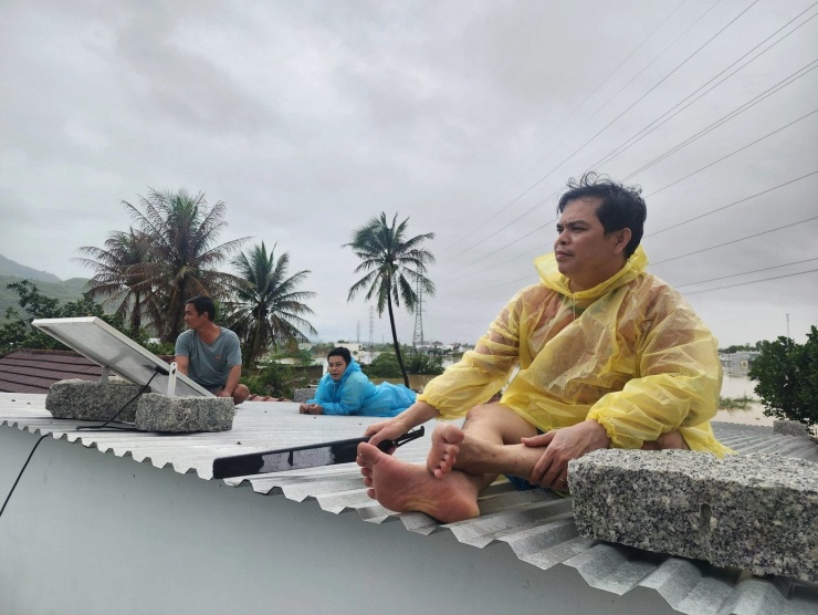 Người dân ngồi trên nóc nhà chờ cứu hộ.