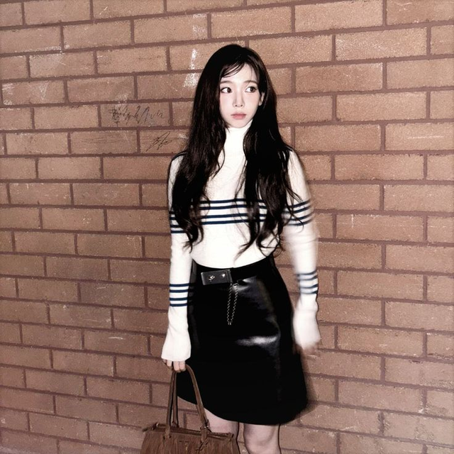 Karina (aespa) khoe dáng với áo len ôm phối chân váy ngắn, nhấn nhá bằng thắt lưng da tối giản.