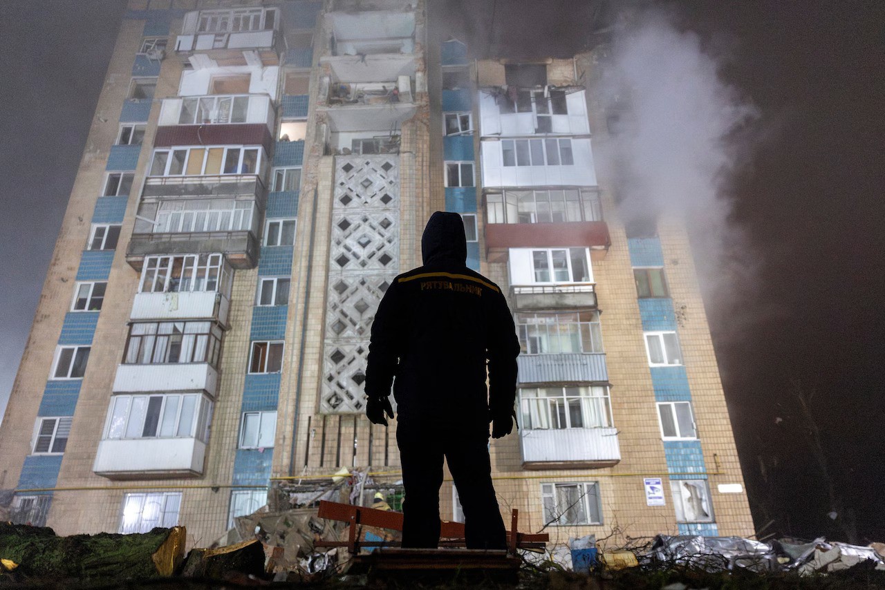 Nhân viên cứu hộ đứng trước một tòa nhà bị hư hại trong vụ tập kích UAV ở Ukraine (ảnh: Reuters)