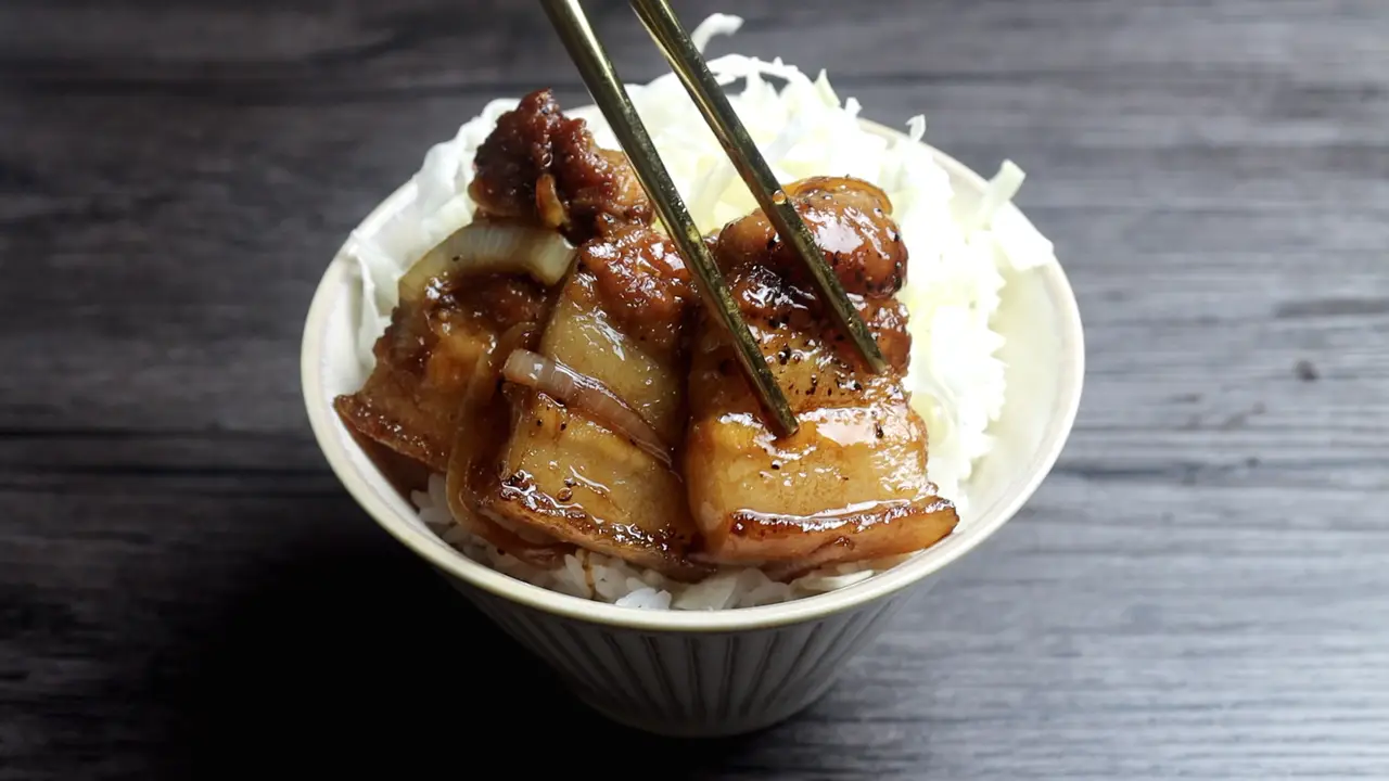 Xếp bắp cải thái sợi lên cơm, múc thịt ba chỉ om hành tây đặt lên trên.