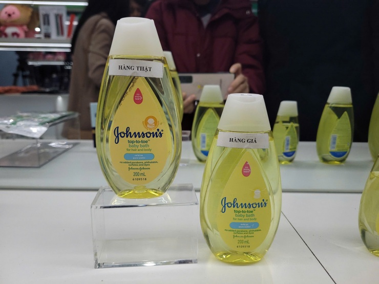 Cận cảnh sản phẩm sữa tắm dành cho đối tượng trẻ em với hàng thật bên trái và hàng giả bên phải. Khi đặt 2 sản phẩm cạnh nhau để nhận diện, không khó để phân biệt sản phẩm thật có màu vàng hơn từ nhãn đến sữa.