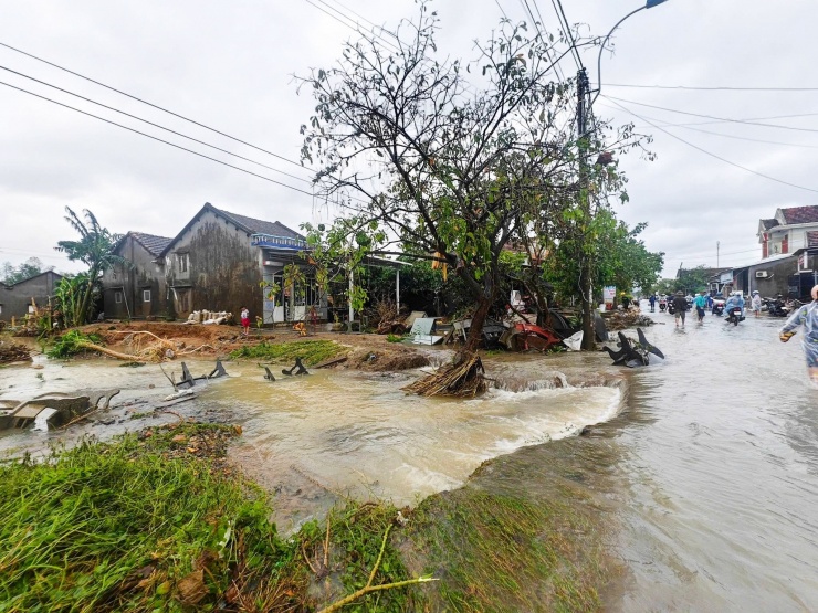 Đường ĐT75 vào xã Hòa Thịnh bị nước lũ băm nát, một số đoạn nước chảy xiết gây khó khăn cho việc đi lại. Ảnh: Trung Đào