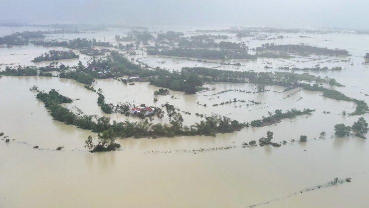 Các đoàn cứu trợ đổ về đầu xã tiếp viện lương thực, thực phẩm cho người dân. Từ trên cao, nước lũ vẫn ngập ở một số khu vực xã.