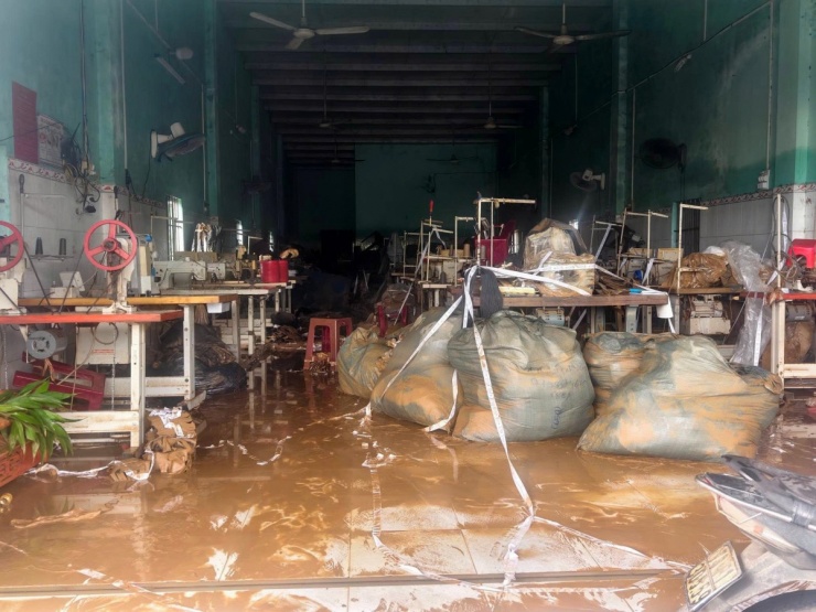 Bùn đất còn đọng lại sau khi lũ rút tại một xưởng may ở xã Hòa Thịnh, nơi nhiều máy móc và hàng hóa hư hỏng nặng sau bốn ngày ngập nước.