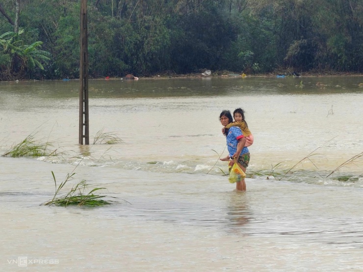 Hai bà cháu lội nước lụt ở xã Hòa Thịnh nhận quà cứu trợ.