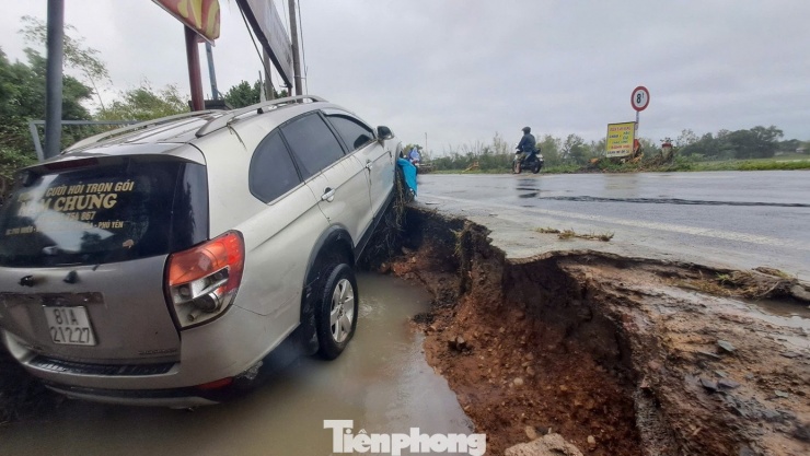 Một chiếc ô tô bên tuyến đường bị lũ đánh sạt.