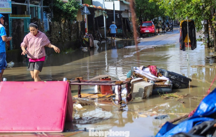 Những khu phố phảng phất mùi bùn đất, xen lẫn tiếng thở dài tiếc nuối khi người dân chạm tay vào những tài sản bị cuốn trôi hoặc hư hỏng. Ảnh: Trương Định.