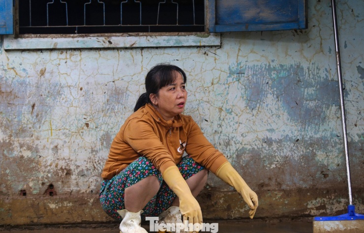 Người dân mệt mỏi sau 2 ngày dọn dẹp lại nhà cửa khi bùn đất bủa vây. Ảnh: Trương Định.