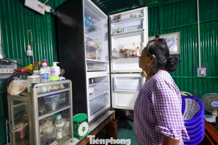 Bà Kiêu Thị Ngọc loay hoay với chiếc tủ lạnh ướt sũng, phơi nắng từ sớm nhưng bật lên vẫn không hoạt động. Bên cạnh là bếp gas, nồi niêu, chén đĩa đặt trong đống bùn đặc sệt. “Ngập cả mấy ngày đêm, nước ăn vô hết rồi. Cái nào không vỡ thì cũng hư mạch điện. Xót của nhưng biết sao được,” bà Ngọc ngậm ngùi.